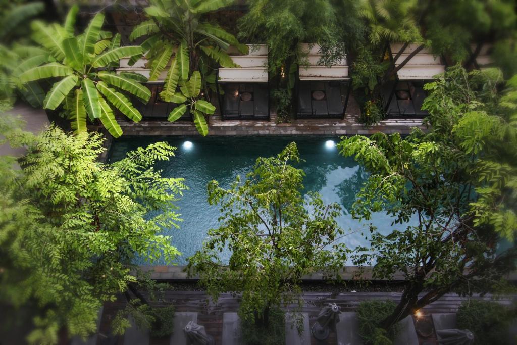 an overhead view of a swimming pool in a building with trees at Larimar Hotel & Resort in Phnom Penh