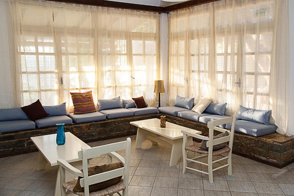 a living room with a couch and tables and windows at Elpida Village in Istro