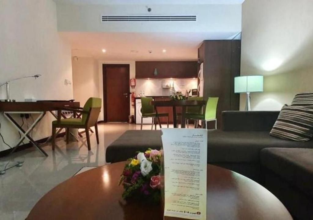 sala de estar con sofá y mesa en Phoenix Plaza Hotel Apartments en Abu Dabi