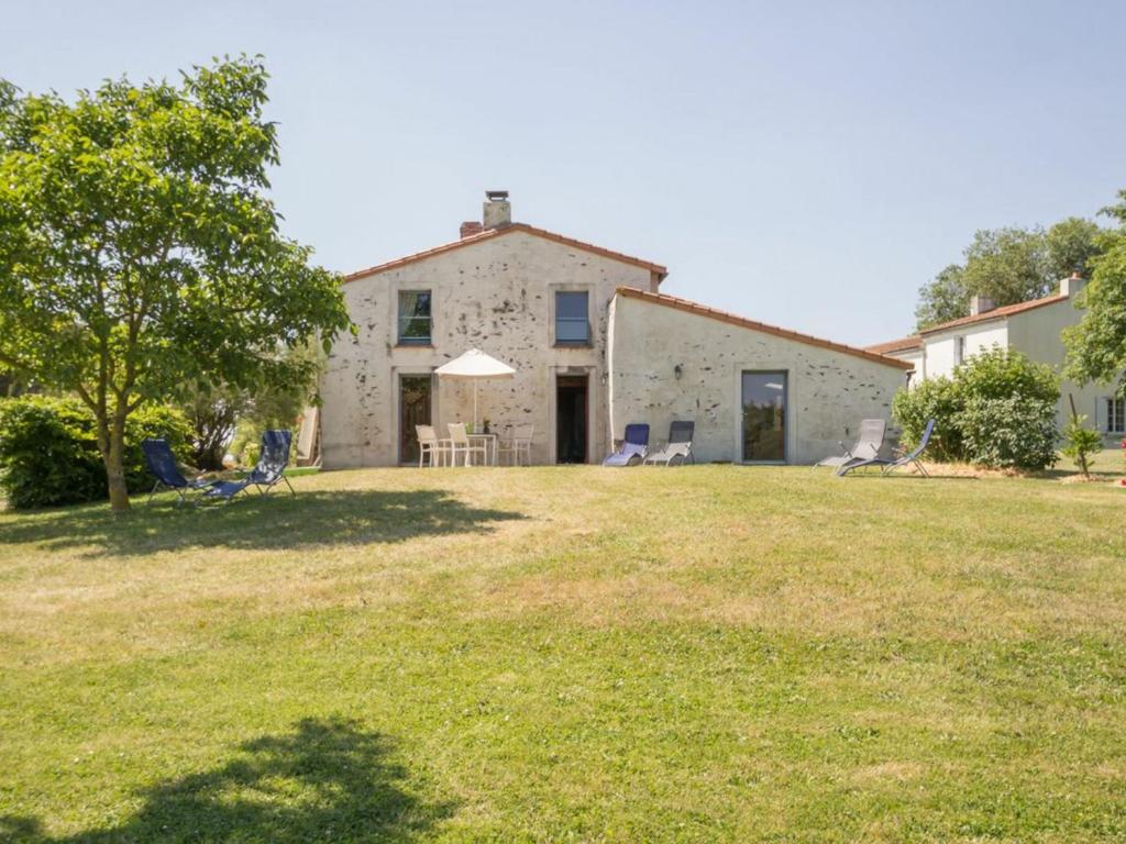 a house with a yard with chairs and a tree at Gîte Le Loroux-Bottereau, 4 pièces, 6 personnes - FR-1-306-800 in Le Loroux-Bottereau