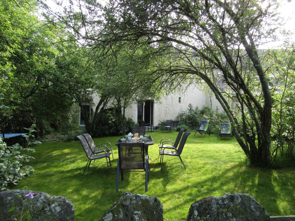 una mesa y sillas en un patio con un árbol en Gîte Saffré, 4 pièces, 6 personnes - FR-1-306-1141, en Saffré