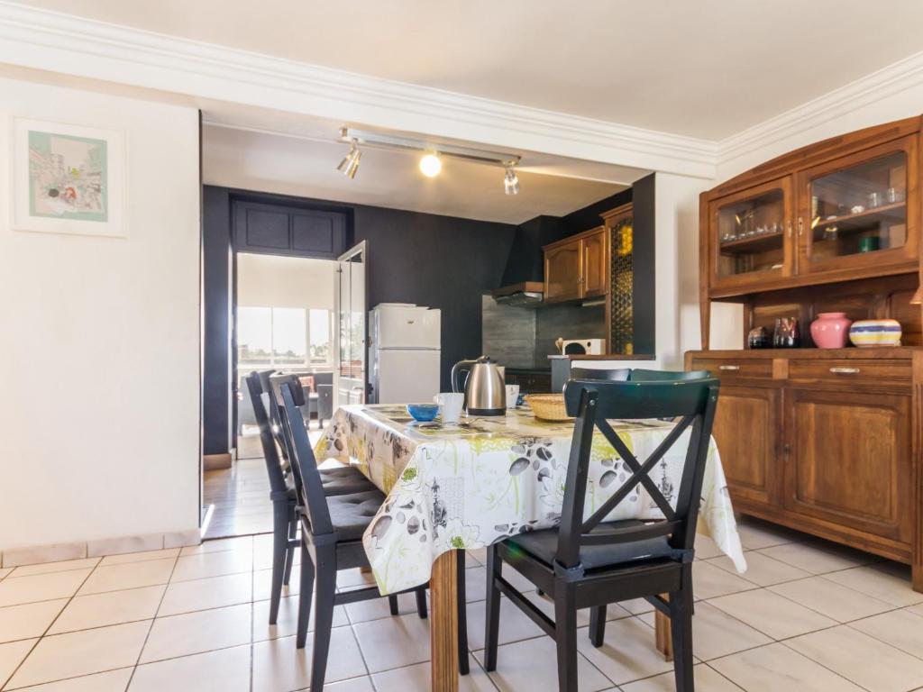 een keuken met een tafel en stoelen en een keuken met een koelkast bij Gîte Nort-sur-Erdre, 4 pièces, 6 personnes - FR-1-306-915 in Nort-sur-Erdre
