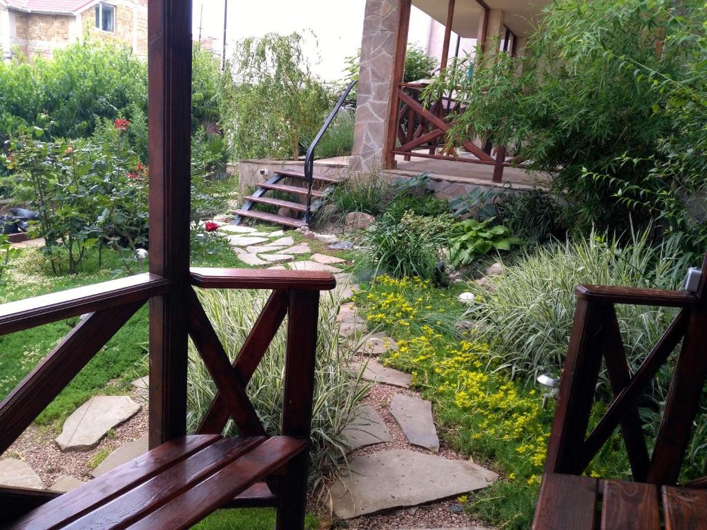 desde un porche con 2 bancos y vistas al jardín en Guest House Gornyy Vozdukh en Yalta