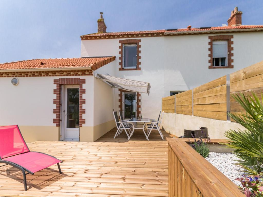 a patio with a pink chair and a house at Gîte Saint-Viaud, 3 pièces, 4 personnes - FR-1-306-1190 in Saint-Viaud