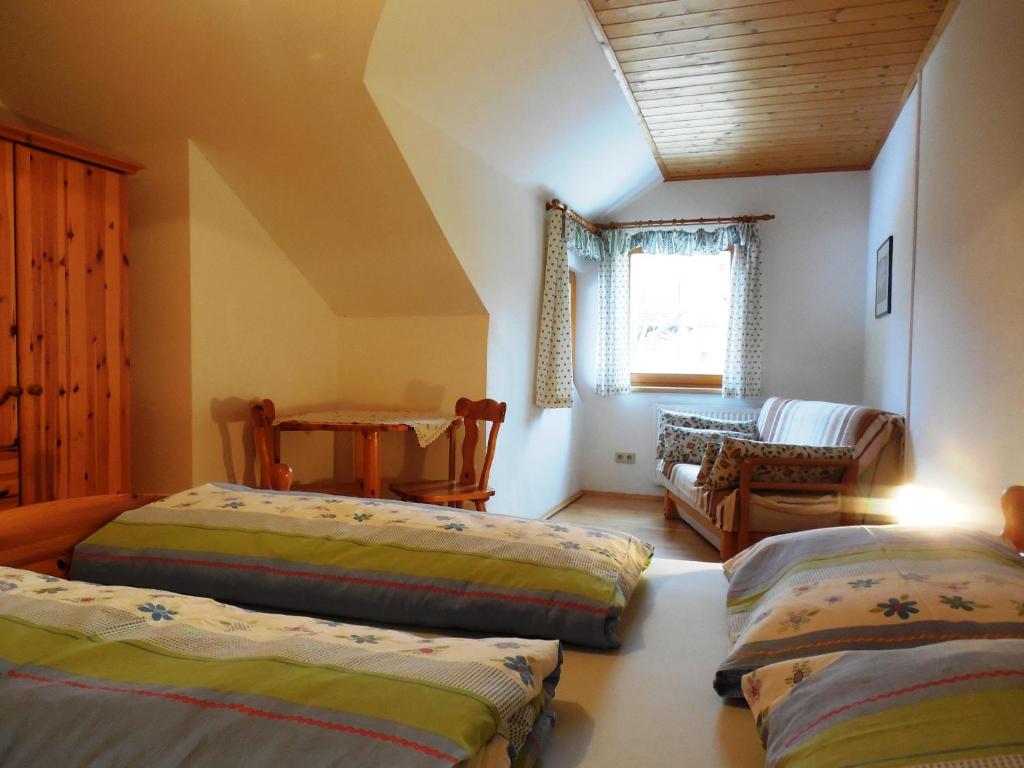 1 dormitorio con 2 camas, mesa y sofá en Naturpark Bauernhof Sperl, en Mariahof