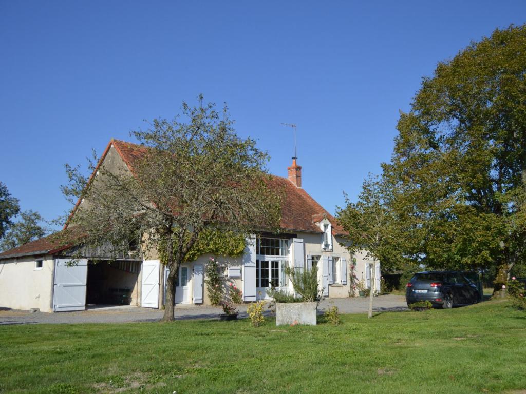 a white house with a car parked in front of it at Ancienne ferme rénovée au cœur de la Vallée Noire avec jardin clos, vélos et équipements complets - FR-1-591-111 in Tranzault