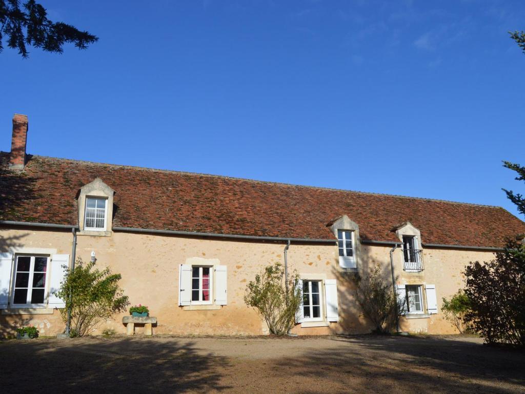 um grande edifício de tijolos com janelas brancas e um telhado em Gîte Argenton-sur-Creuse, 7 pièces, 12 personnes - FR-1-591-209 em Argenton-sur-Creuse