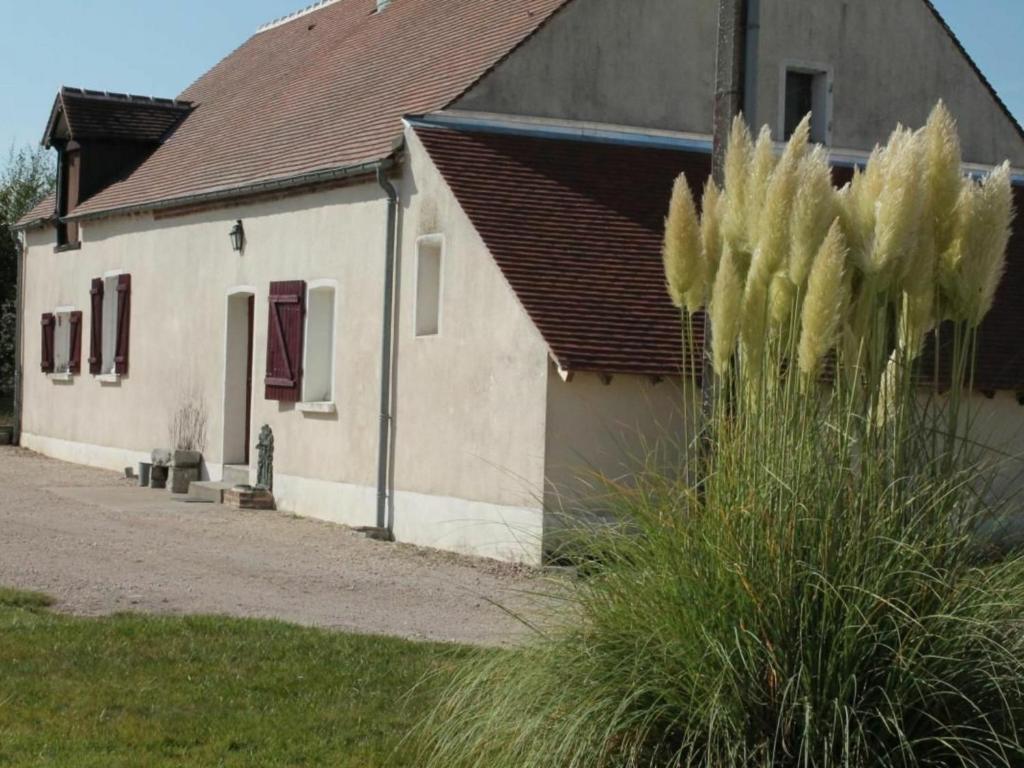 una casa blanca con una planta delante en Gîte Jouy-le-Potier, 3 pièces, 4 personnes - FR-1-590-54, en Jouy-le-Potier