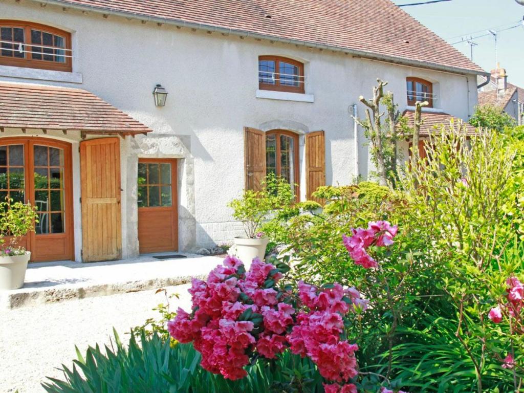 una casa con flores rosas delante de ella en Gîte Tavers, 4 pièces, 6 personnes - FR-1-590-106, en Tavers