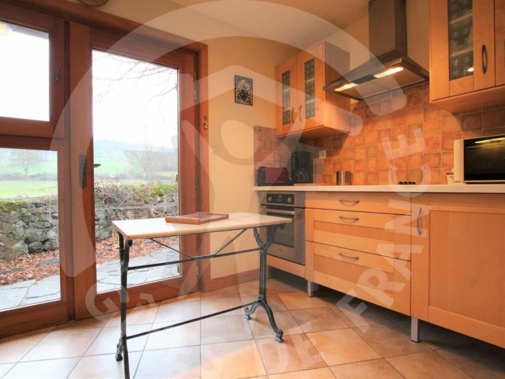 a kitchen with a counter and a table in it at Gîte Polignac, 3 pièces, 5 personnes - FR-1-582-117 in Polignac