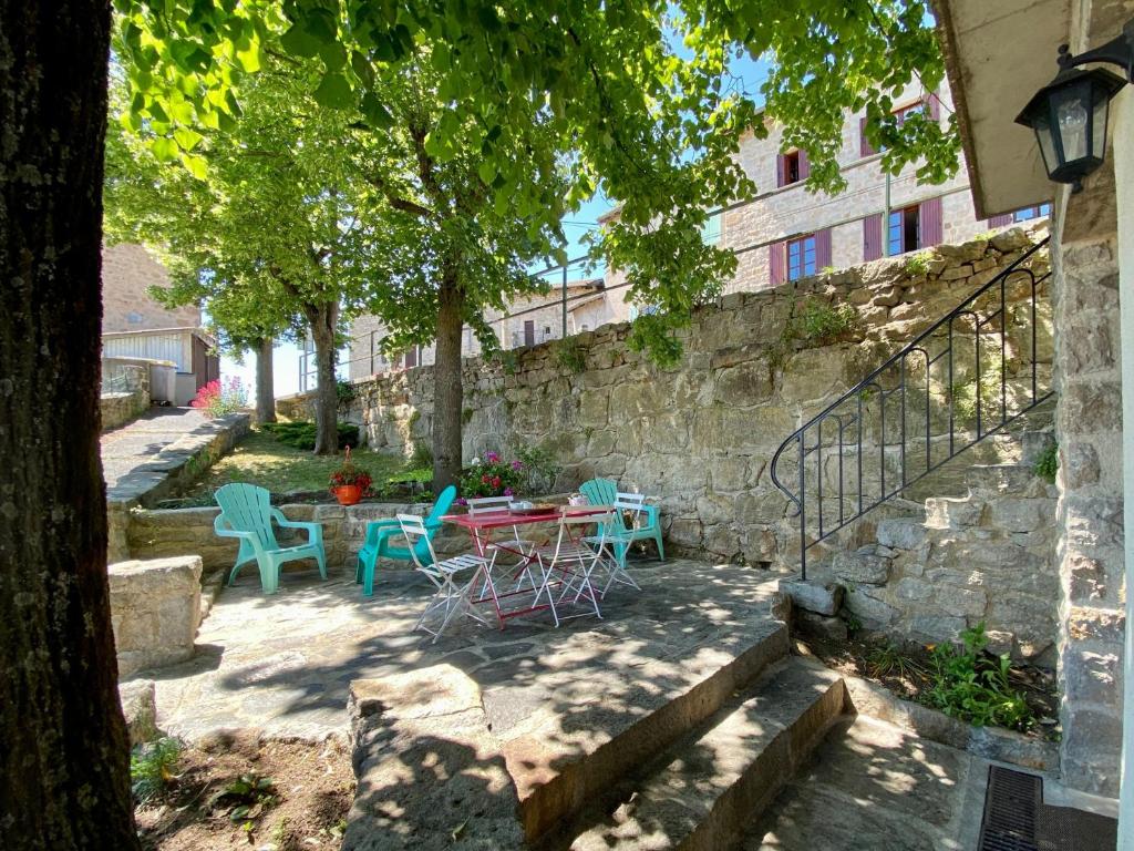 un patio con mesa y sillas junto a una pared de piedra en Gîte Blavozy, 2 pièces, 3 personnes - FR-1-582-57, en Blavozy