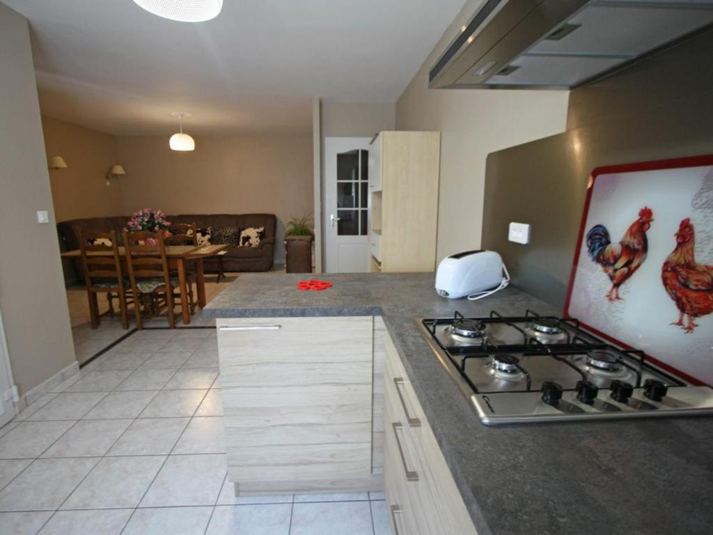 a kitchen with a stove top and a living room at Gîte Hagécourt, 3 pièces, 4 personnes - FR-1-589-138 in Hagécourt