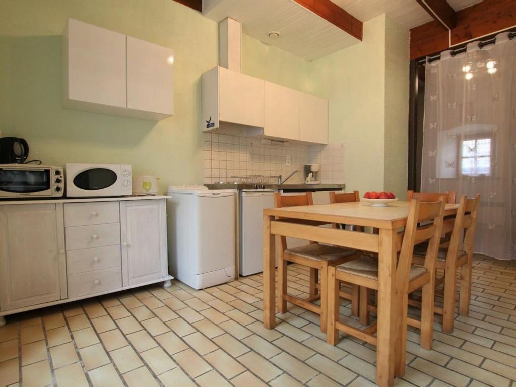 een keuken met een tafel en stoelen bij Gîte Chavaniac-Lafayette, 3 pièces, 4 personnes - FR-1-582-175 in Chavaniac-Lafayette