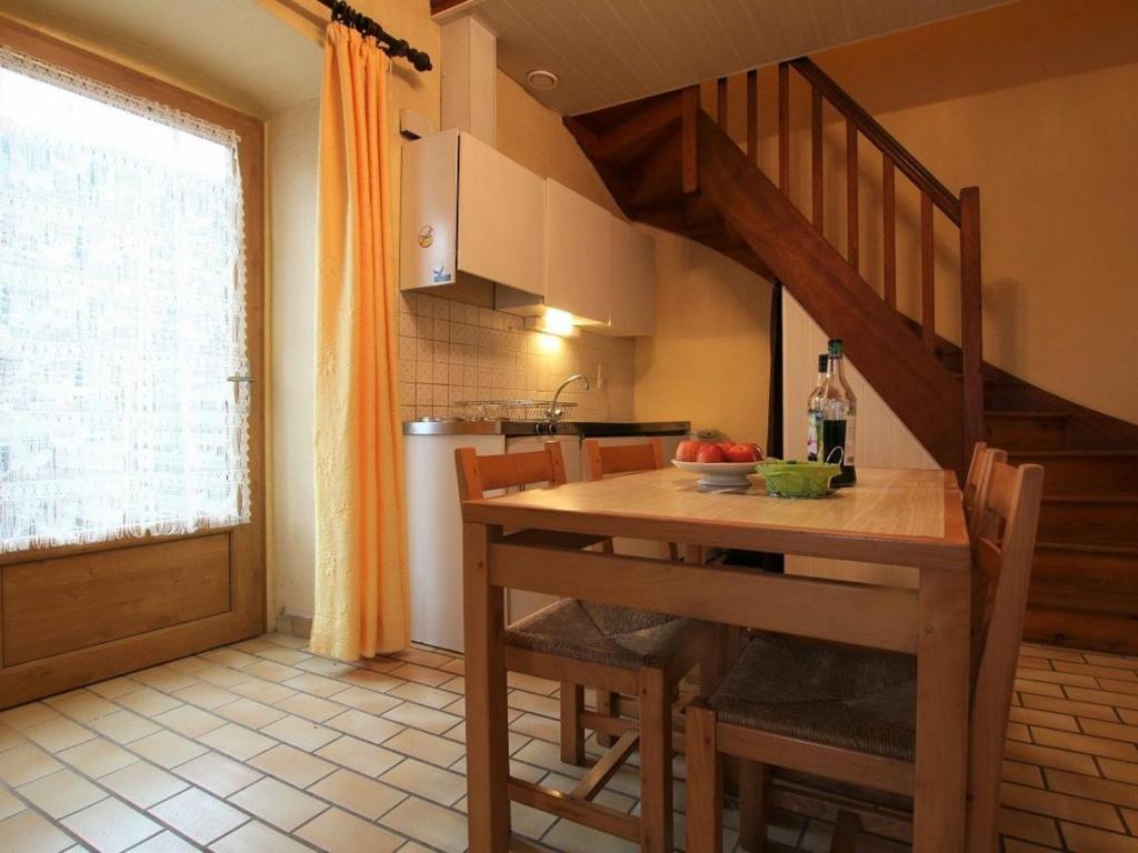 een keuken met een houten tafel en een trap bij Gîte Chavaniac-Lafayette, 2 pièces, 2 personnes - FR-1-582-198 in Chavaniac-Lafayette