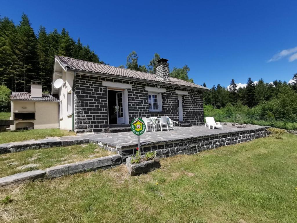 uma pequena casa com um pátio de pedra num quintal em Gîte Champclause, 4 pièces, 6 personnes - FR-1-582-259 em Champclause