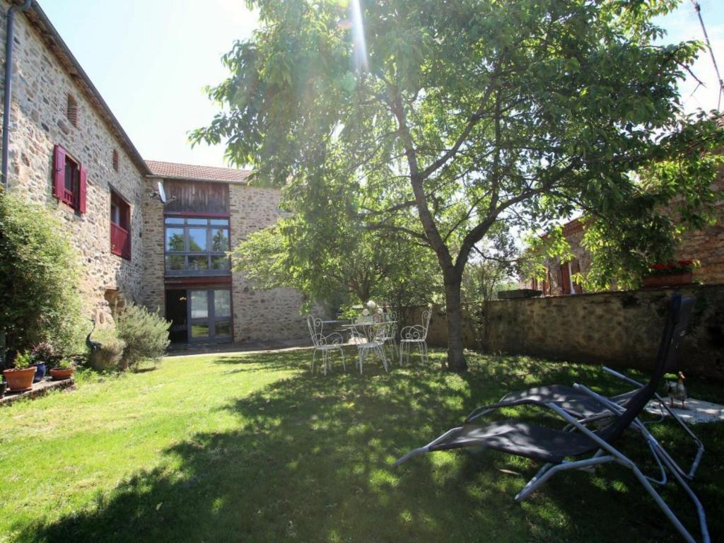 un patio con un árbol y un edificio en Gîte Saint-Beauzire, 4 pièces, 6 personnes - FR-1-582-210, en Saint-Beauzire