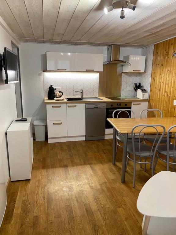 eine Küche mit weißen Schränken und einem Tisch mit Stühlen in der Unterkunft Cathy in Les Angles