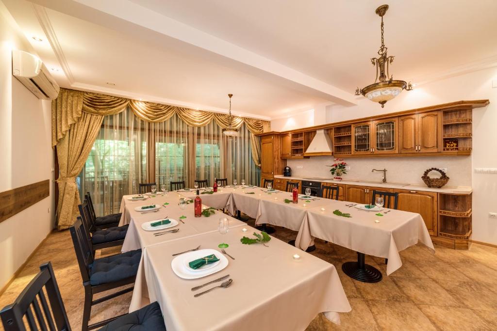 a dining room with white tables and chairs at Blaguna Eco Complex in Varna City