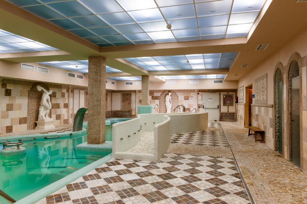 a swimming pool in a building with a swimming pool at Hotel Comendador in Carranque