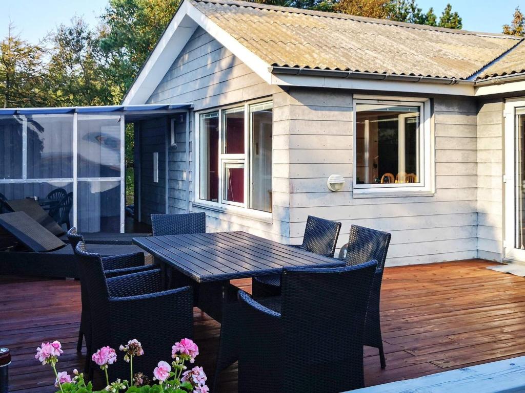 Sønder Ydbyにある6 person holiday home in Hurup Thyのパティオ(木製テーブル、デッキの椅子付)