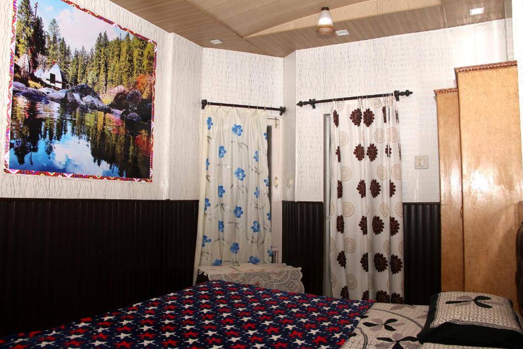 a bedroom with a bed and a painting on the wall at Hotel Tip Top in Solan