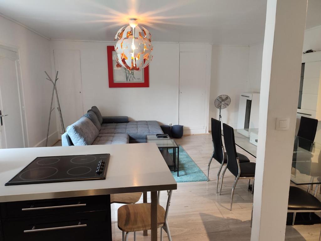 Appartement Cosy et Lumineux في تور: مطبخ وغرفة معيشة مع أريكة وطاولة