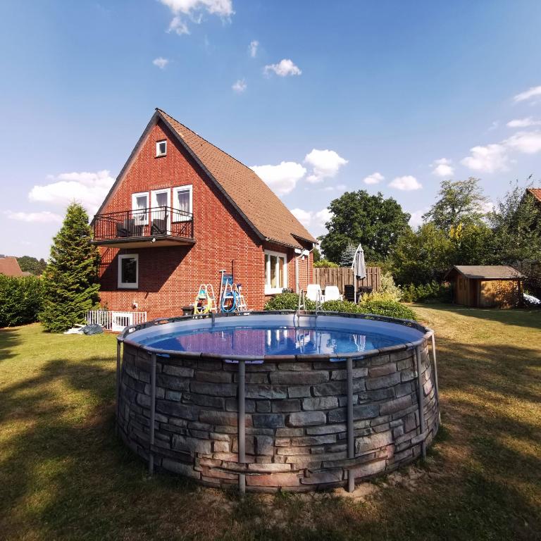 a large pool in the yard of a house at Landhaus Lüneburger Heide "Ferienhaus bis 6 Personen" in Neuenkirchen