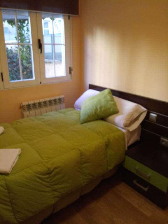 a bedroom with a bed with yellow sheets and pillows at Ávila Flats Pz Ejército Avila in Ávila