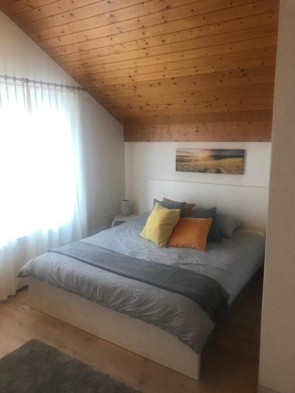 a bed in a bedroom with a wooden ceiling at Studio Central Grindelwald in Grindelwald