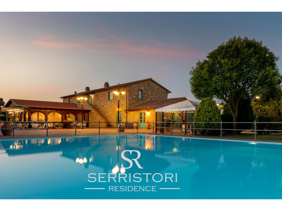 a large swimming pool in front of a house at Residence Serristori in Castiglion Fiorentino