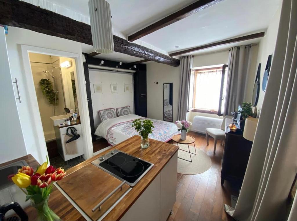 a bedroom with a bed and a kitchen with a table at Studio au cœur du Vieil Antibes in Antibes