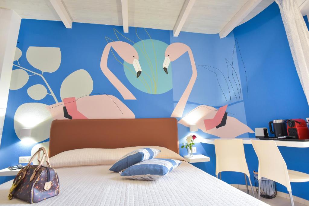 1 dormitorio con un mural de flamencos en la pared en Vicocolli Rooms, en Muravera