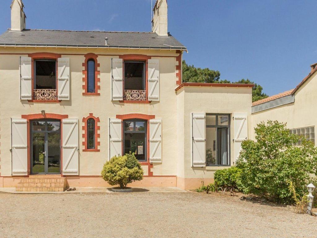 a large house with red windows and a driveway at Gîte Saint-Brevin-les-Pins, 4 pièces, 6 personnes - FR-1-306-1065 in Saint-Brevin-les-Pins