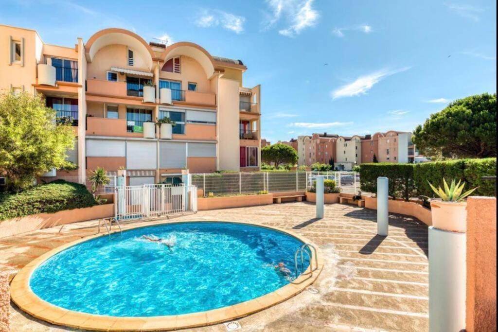 una piscina frente a un edificio en APPARTEMENT SUR LE PORT DE Gruissan, en Gruissan