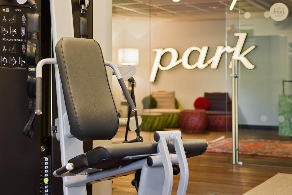 a gym with a bench in a room at At the Park Hotel in Baden