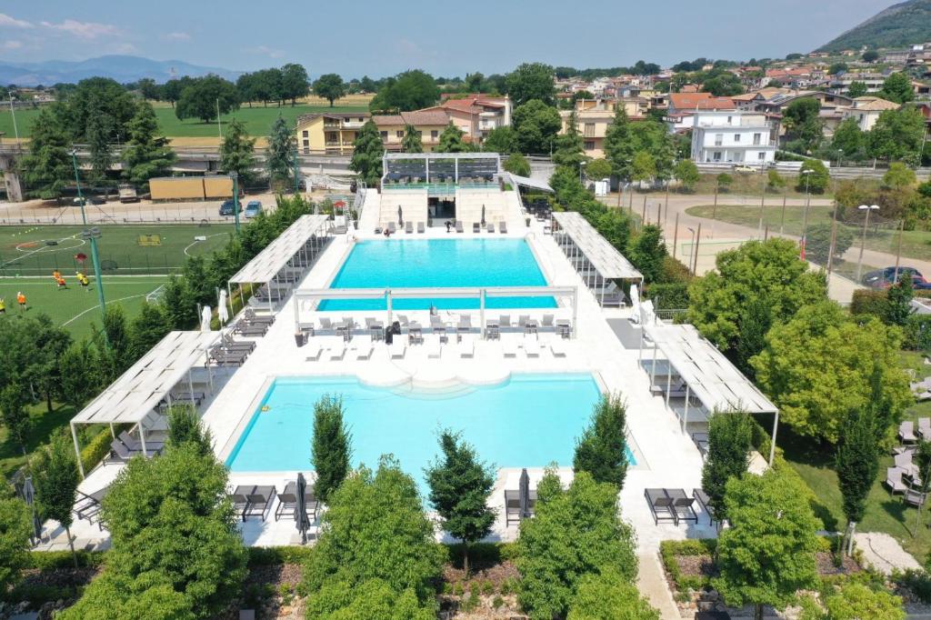 uma vista sobre uma piscina com cadeiras e árvores em Kairos Resort & SPA em Piedimonte San Germano