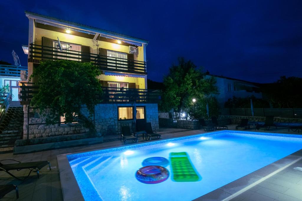 una piscina frente a un edificio por la noche en Apartments Mila en Klenovica