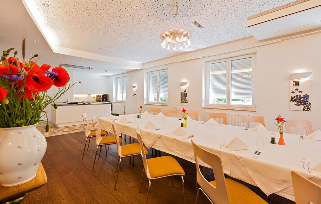 a large room with a long table with chairs and flowers at At the Park Hotel in Baden