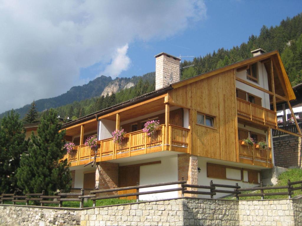 a house with a balcony on a mountain at Appartamenti Decrestina in Campitello di Fassa