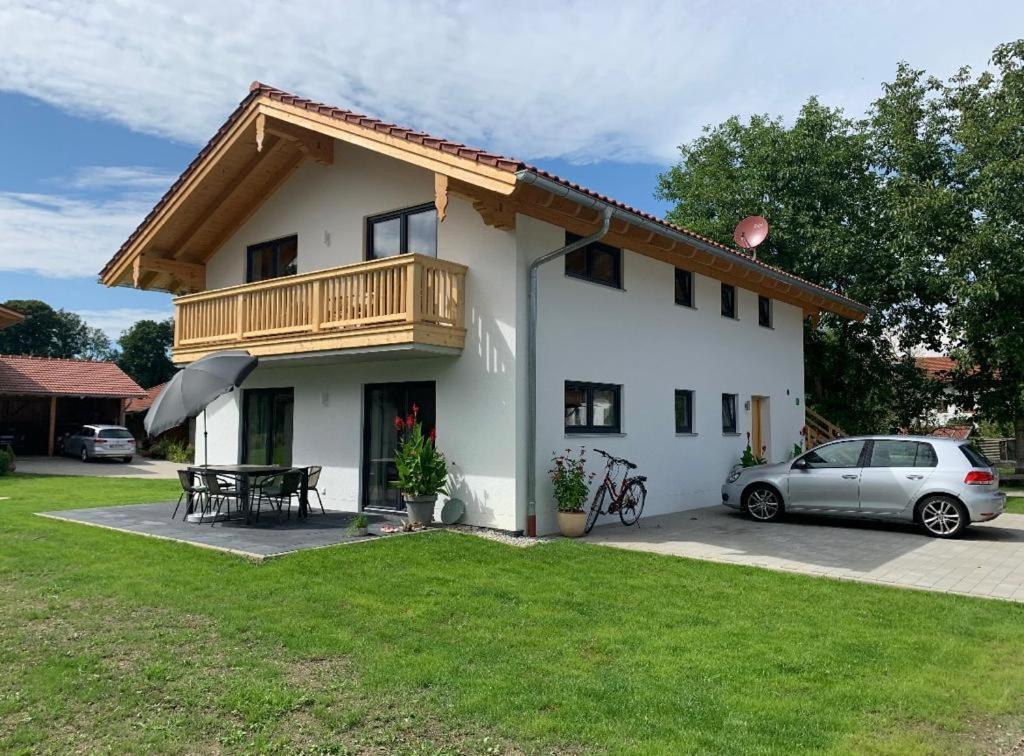 a house with a car parked in front of it at Chiemsee Pferdehof Ferienwohnungen in Bernau am Chiemsee