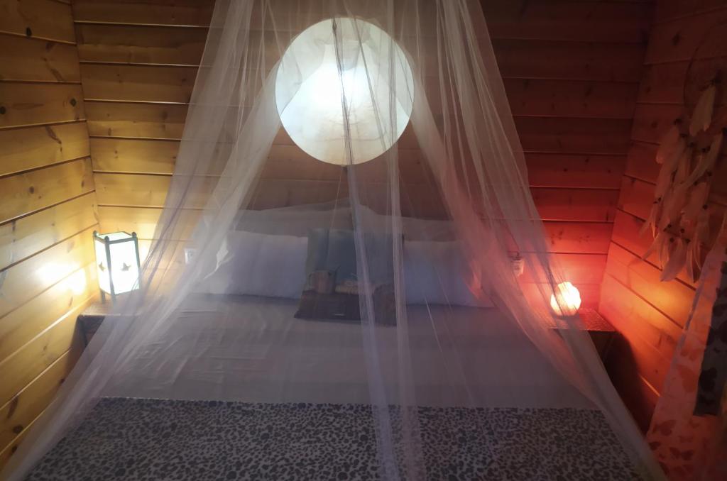 a room with a bed with a curtain at Casa La Colina Mandarina I in Tahal