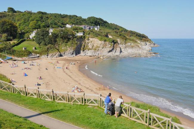 a group of people standing on a beach at Glyncoch Aberporth in Aberporth