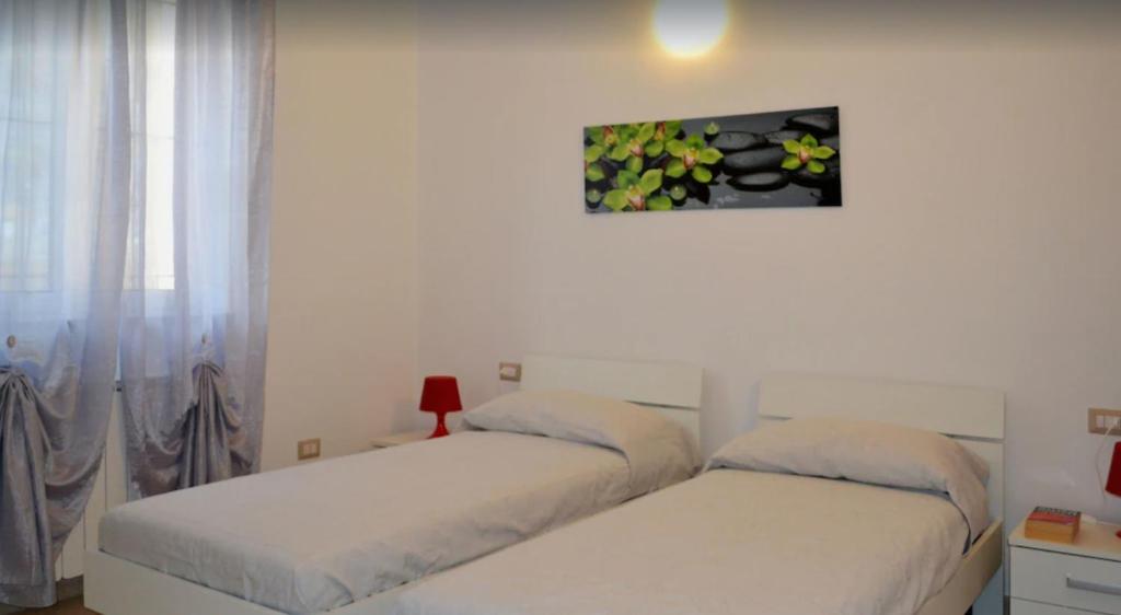 sypialnia z 2 łóżkami i obrazem na ścianie w obiekcie Casa di Gian w mieście Arnasco