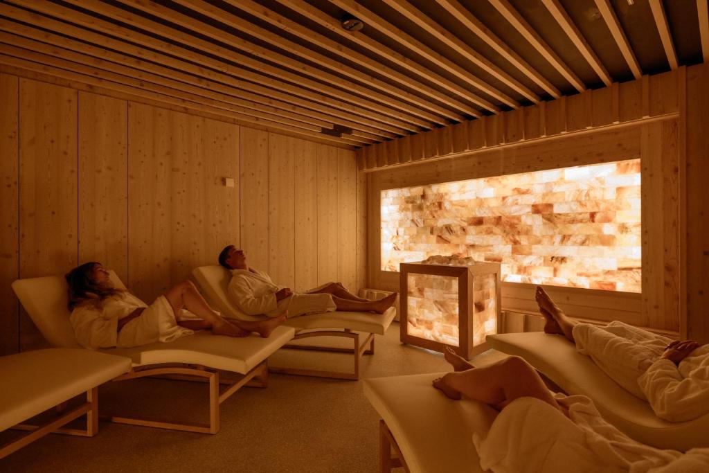a group of people sitting on couches in a room at Hotel Bohinj in Bohinj