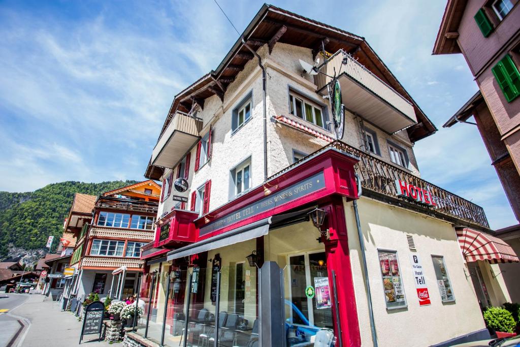 un edificio con adornos rojos en una calle de la ciudad en Hotel Tell and Apartments, en Interlaken