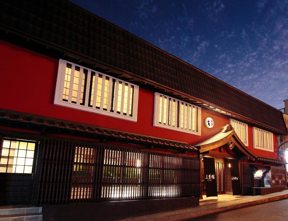 a red building with white windows on a street at Goyokan in Izu