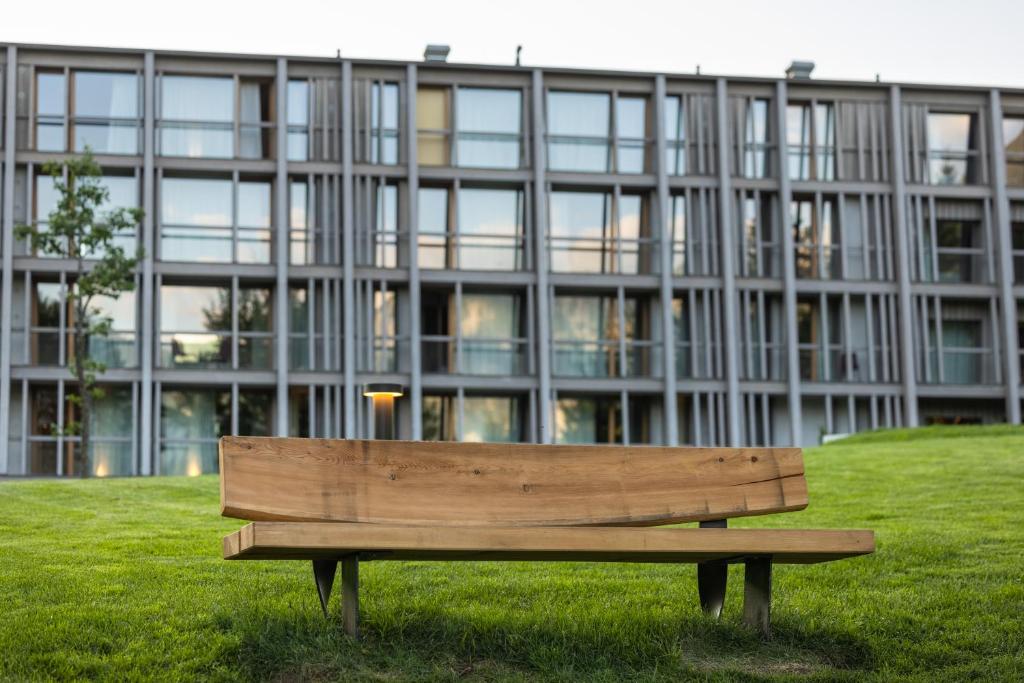 a wooden bench sitting in front of a building at Hotel Bohinj in Bohinj