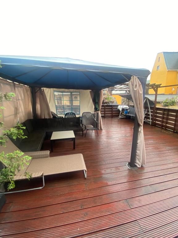 a deck with a blue canopy on top of a building at Ferienwohnung mit Terrasse in Aue