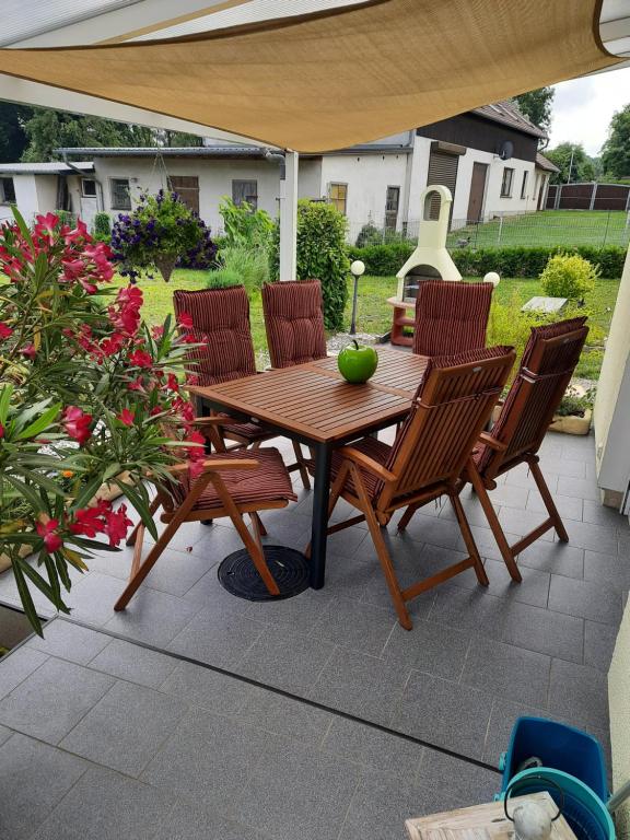 PudaglaにあるFerienwohnung am Schmollenseeの木製テーブルと椅子付きのパティオ