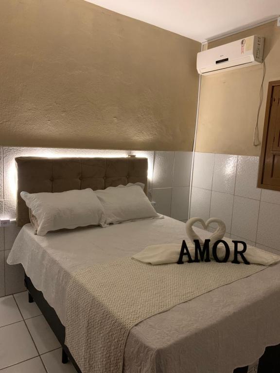 uma cama com um sinal que diz amor em Casa Praia São José Maragogi 50m Mar em São José da Coroa Grande